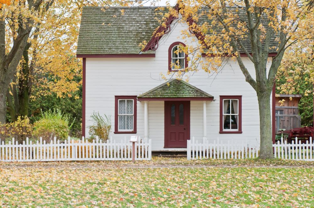 a house with a fence in front of a building